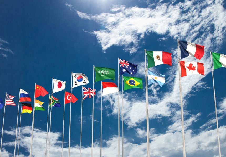 Many flags waving in blue sky.