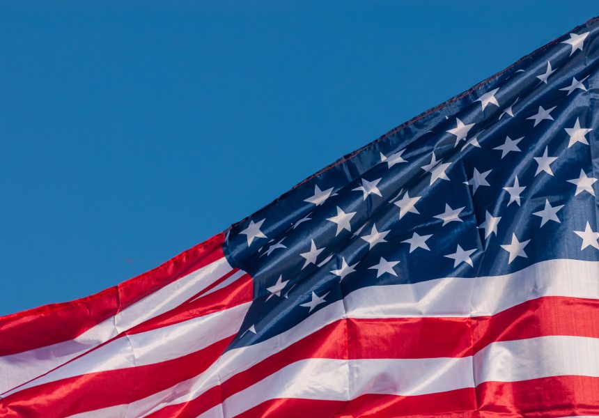 American flag waving in blue sky.