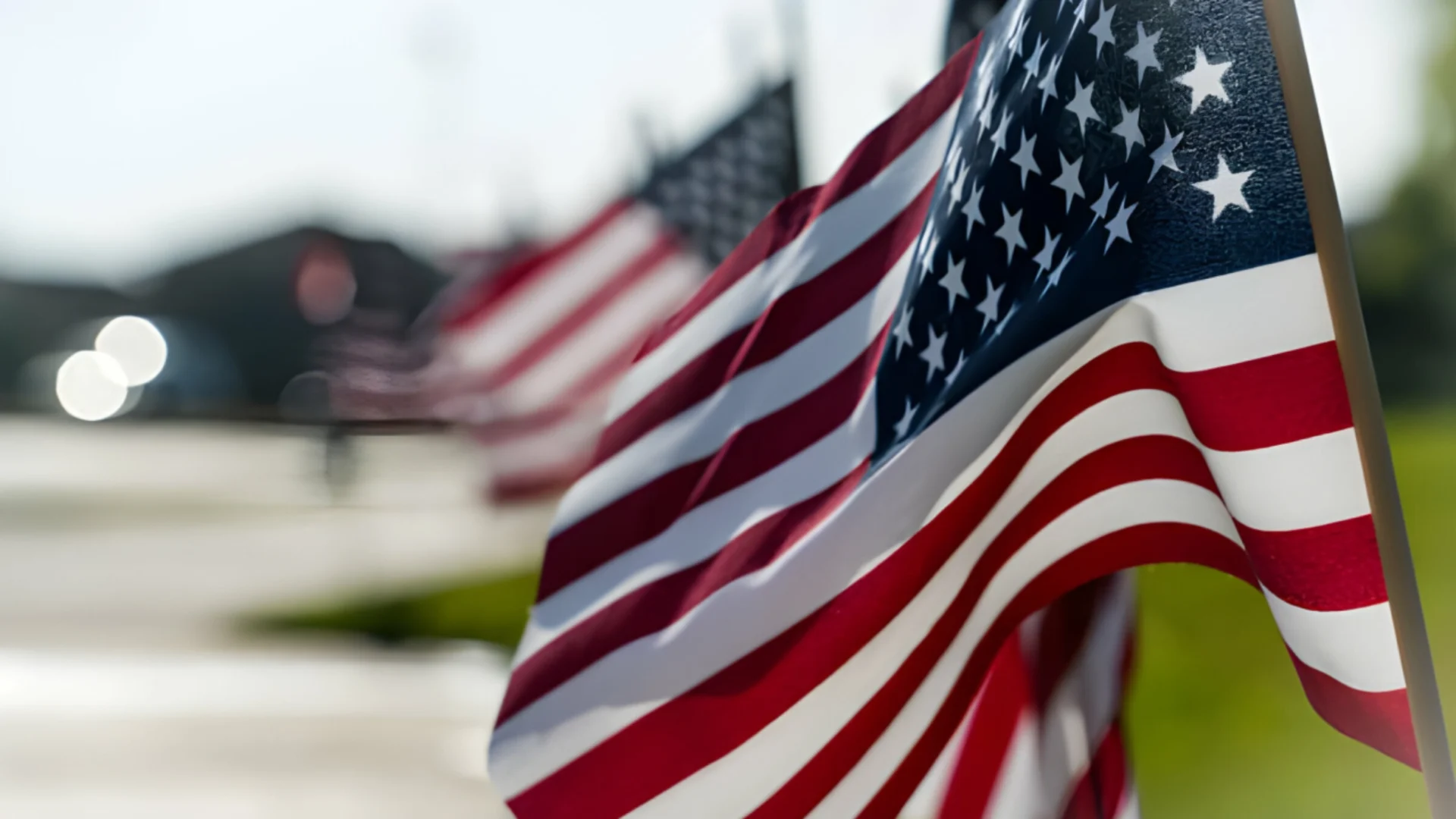 Close-up of multiple American flags waving outdoors.